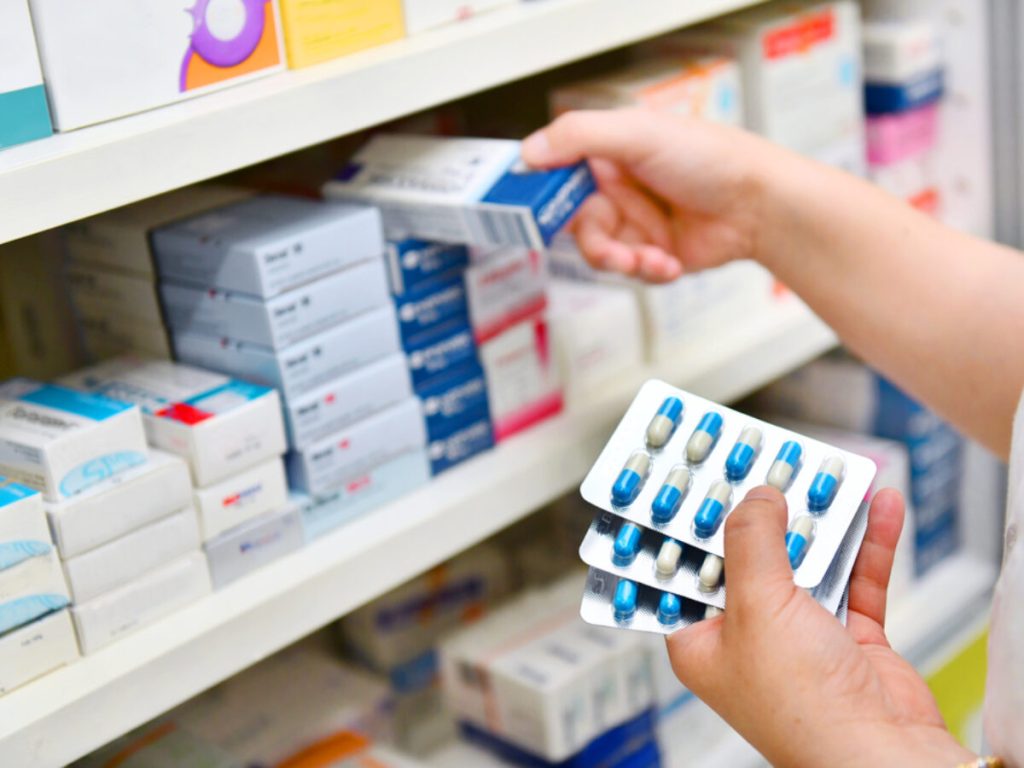 Pharmacist,Holding,Medicine,Box,And,Capsule,Pack,In,Pharmacy,Drugstore.